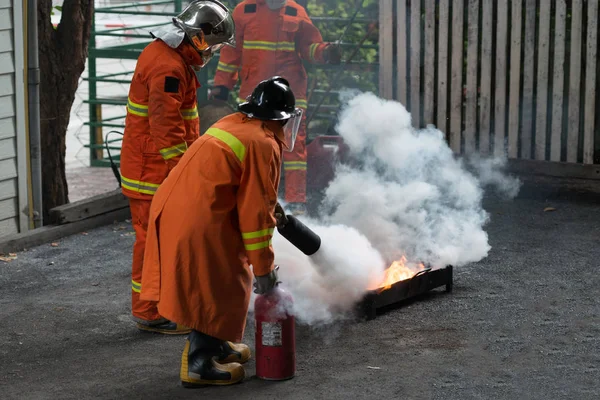 講師は 消火器を使用する方法を示します 火にガソリン タンク トレーニング中に — ストック写真