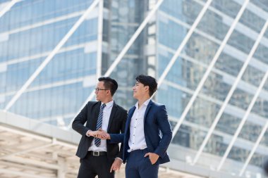 Takım elbise ayakta başarılı iki iş adamı. O el sıkışma git büyük şehir binaları, Toplantı başlatmak bekleyen yeni projelerin planlanması seyir şehirde olmak. Metin için yer kopyalayın