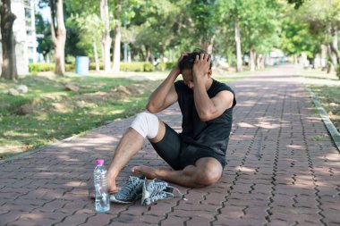 Asya genç adam runner inflamasyon vardır ve neden şişme bir acı acıyan diz, sağlıklı yaşam ve erkekler kafa touch ve ağrı hissediyorum. egzersiz from yaralanmaları kavramı.