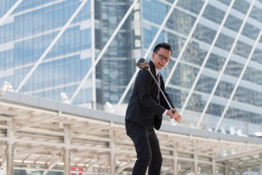 Takım elbiseli başarılı bir iş adamı. golf ekipmanları kentin ayakta tutan el. Şehir arka plan başarı kavramı