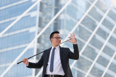 Takım elbiseli başarılı bir iş adamı. golf ekipmanları kentin ayakta tutan el. Şehir arka plan başarı kavramı