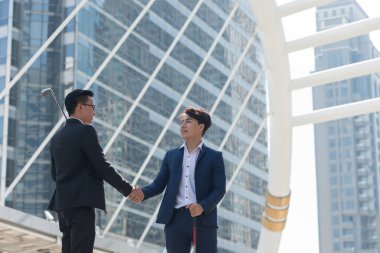 el sıkışma şehri ofis bina arka planda olmak golf ekipmanları elinde tutan bir iş adamı. İş fırsatlar kavramı