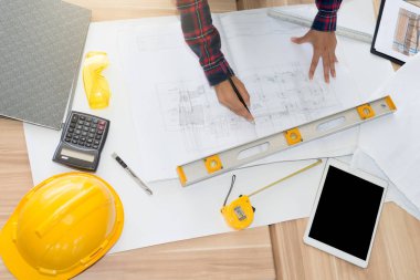 Kadın mimar tablo Müfettiş wood.engineer işyerinde - mimari proje, planları, cetvel, hesap makinesi, Gözlük, dijital tablet ve kask üzerinde çalışma. İnşaat kavramı.