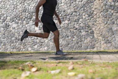 Gündoğumu sırasında verilen sürede baraj yolu üzerinde çalışan bir adam Asya bacaklar görünümünü aşağı egzersiz. Sağlıklı yaşam tarzı