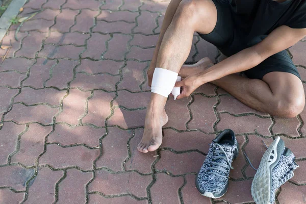 Lesão Desportiva Ásia Jovem Corredor Está Rebobinando Bandagem Tornozelo Homem — Fotografia de Stock