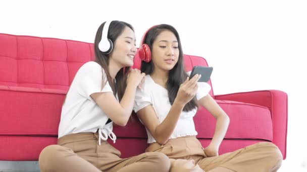Δύο Ασιάτισσες Έφηβες Κάθονται Στο Πάτωμα Ακούγοντας Μουσική Μορφή Smartphone — Αρχείο Βίντεο