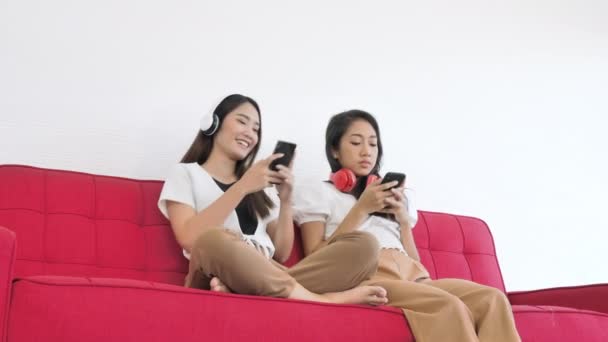 Due Adolescenti Asiatiche Sedute Sul Divano Rosso Ascoltano Musica Usano — Video Stock