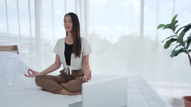 Gündelik Giysiler Içindeki Asyalı Genç Kız Bilgisayar Laptopuyla Yatakta Meditasyon — Stok video