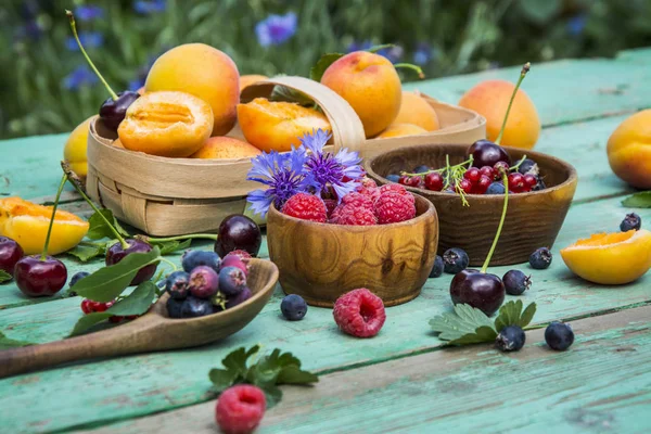 Fruits. Fruit background. Fruit in drops of water. Fruits in a basket. Cherries, cherries, raspberries, strawberries, currants, blueberries, apricots, mint.