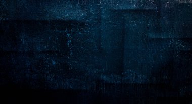 Mavi koyu duvar, sıva, koyu beton. Karanlık dekoratif taş. Spot ışığı. Boş gece duvarı, neon mavi ışık.