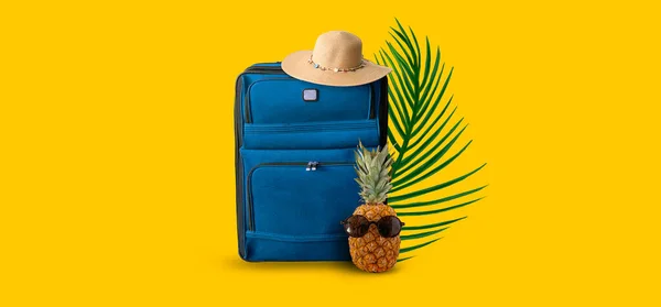 Summer abstract marine background for travel. Pineapple with glasses, a suitcase with a hat, palm branches. Reflection on the water. Blue suitcase and summer wicker hat. Pineapple with glasses. Palm branches. Summer background for travel.