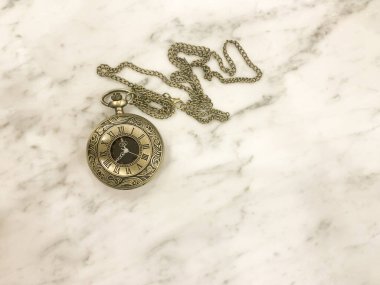 Zincirli bir saat, bronz metal. Mermer masa, parlatıcı..