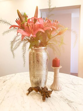 Yaz çiçekleri, misket masasında vazodaki zambaklar. Çiçekli bir yemek odasının içinde..