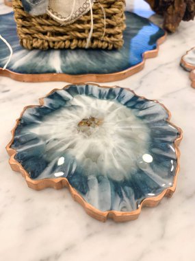 Bardak tutacağı, epoksi reçine tepsisi, deniz usulü taş kesimi. Mavi boya lekeleri, altın kaplama. Masa ayarı için konu. Parlak, yansıma.