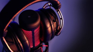 Mirkoponlu ve neon ışıklı kulaklıklı oyun kulaklıkları. Oyun aletleri, neon ışıklar. Oyun alanı.