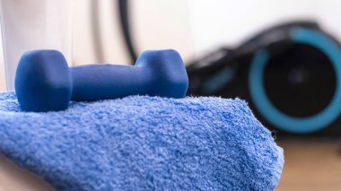 Spor geçmişi, mavi aksanlı dambıl, cam, havlu, elepsoid. Spor aktiviteleri. Evde spor, spor için özellikler. Etkin yaşam biçimi.