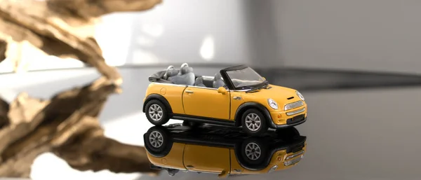 コンバーチブルモデルグレーの背景に黄色のミニクーパー 黄色のおもちゃの車は 鏡の床に反映された光の背景に乗っています 2020年7月31日ベラルーシ ゴメル — ストック写真