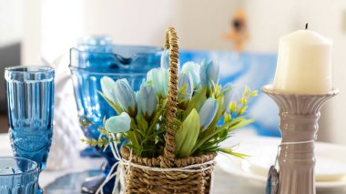 Geniş pencereli hafif yemek odası. Meşe tabanlı mermer masa. Beyaz yemekler ve mavi bir aksanla servis yapmak. Mavi bardaklar, çiçekler.