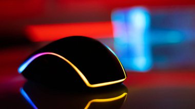 Beyaz parlak bir masa üzerinde neon ışıklı bilgisayar faresi, karanlık oda, neon ışık, diyotlar. Oyun aletleri, neon ışıklar, beyaz parlak masa. Yaşam tarzı, oyun alanı.