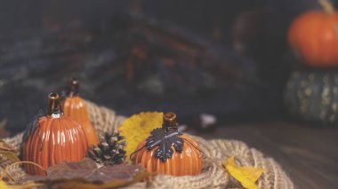 Portakal kabakları ve sonbahar yaprakları yumuşak örülmüş bir eşarp, sonbahar arkaplanı, şöminenin yanında sıcak bir akşam.