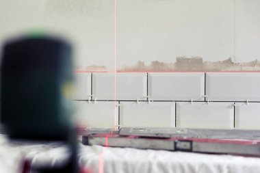 İnşaat lazer eşitlikçi kullanarak mutfak fayans döşeme işlemi. Ev geliştirme, yenileme kavramı