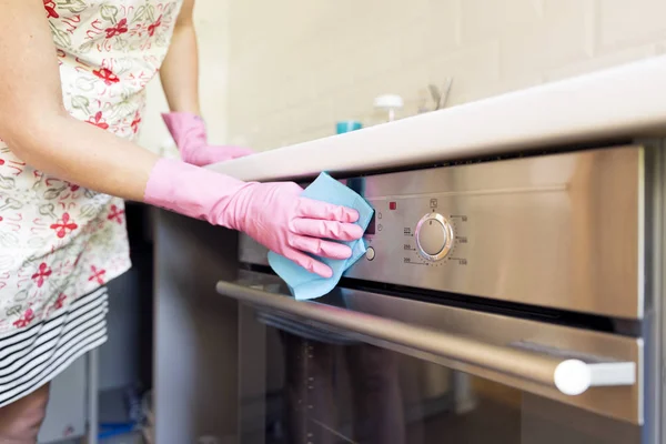 Χέρι Της Γυναίκας Ροζ Προστατευτικά Γάντια Καθαρισμού Πόρτα Του Φούρνου — Φωτογραφία Αρχείου