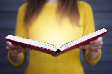 Kadının elinde kitap gelen ışık. Bilgelik, din, okuma, hayal gücü, bilgi kavramı