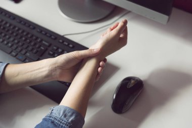 Ofis sendromu, iş yerinde bilgisayar kullanırken el ağrısı çeken genç bir kadın. Mesleki risk faktörü. Sağlık ve tıbbi konsept.