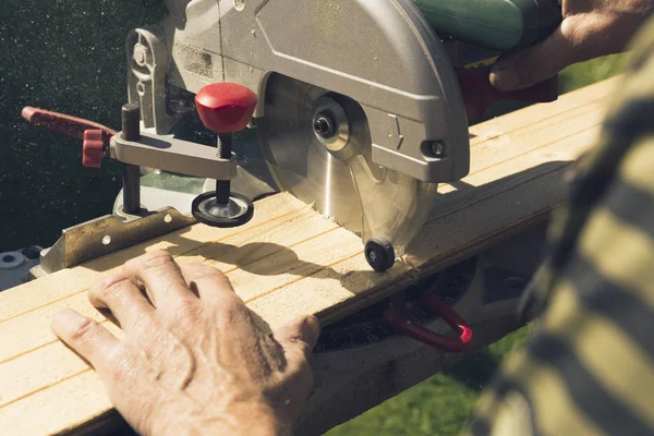 Senior men preparing wood materials with rotary saw