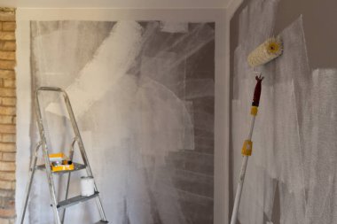 Boyama, rulo, fırça, alüminyum lider için araçlar. Duvar kısmen renkli. Boya silindiri odaklı.