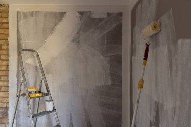 Boyama, rulo, fırça, alüminyum merdiven için araçlar. Duvar kısmen renkli. Alüminyum Merdiven üzerinde odaklanılan.