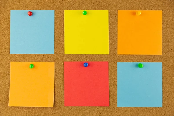 Colorful paper pined to cork board as reminders.
