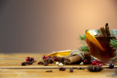 Noel şarabı tarçınlı, baharatlı ve portakal dilimli ahşap arka planda. Sıcak kış içeceği