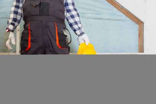 Man installing thermal roof insulation layer - using mineral wool panels. Attic renovation and insulation concept