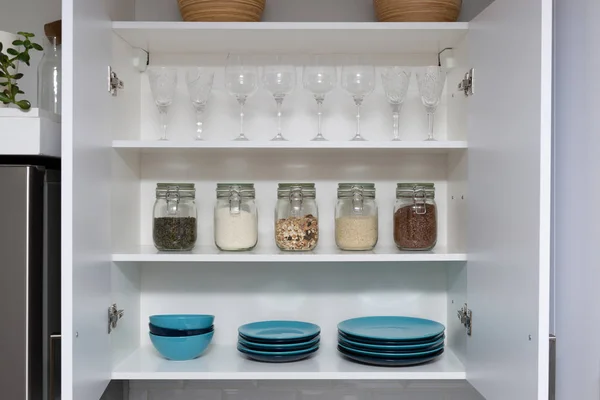 Várias sementes em frascos de armazenamento em despensa, cozinha moderna branca em — Fotografia de Stock