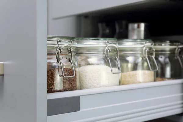 Various seeds in storage jars in hutch, white modern kitchen in
