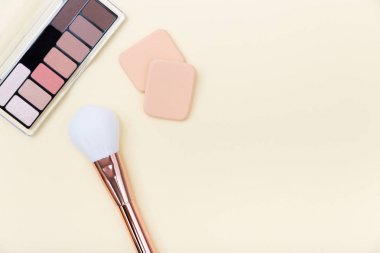 Decorative cosmetics, makeup products and brushes on light pink 