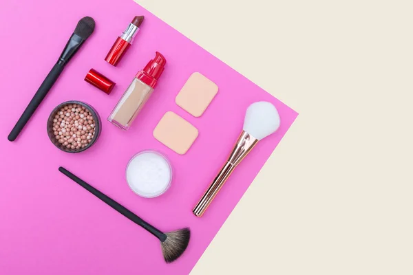 Cosmétiques décoratifs, produits de maquillage et brosses sur fond rose — Photo