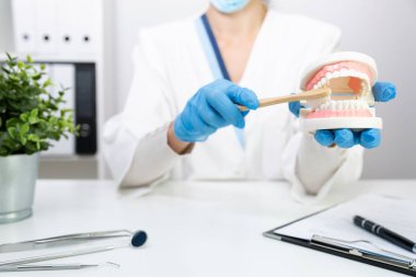 Kadın diş hekimi klinikte diş fırçalama hakkında açıklama, t t t t t t