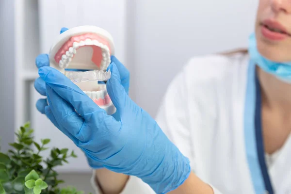 歯のモデルと矯管切開シリコーントライを保持する女性歯科医 — ストック写真