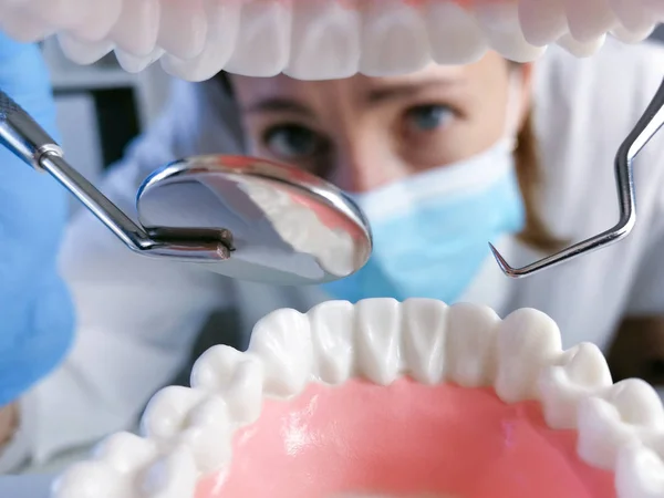 Dentista femenina sosteniendo herramienta de estomatología profesional y punción — Foto de Stock