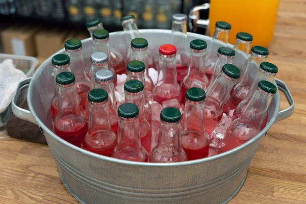 Cold bottles of drinks in bucket on a stall on open kitchen stre — Stock Photo, Image