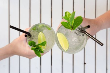 Açık hava bar restoranında mojito kokteyli içen iki kadın. Su