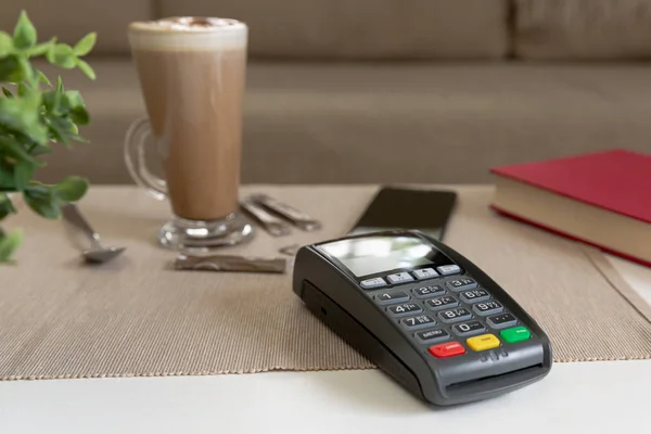 Платежный автомат и смартфон на столе в кафе, оплата nfc — стоковое фото