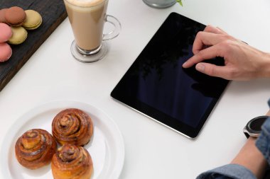 Kafede tablet kullanan akıllı saati olan kadın. Kahve ve pa