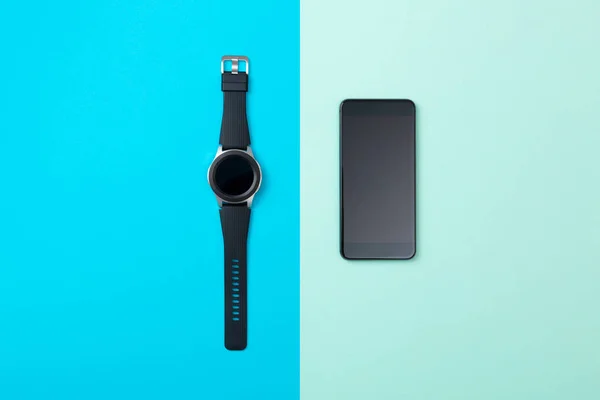 Widok z góry smartfona i zegarka SmartWatch na jasnoniebieskim tle — Zdjęcie stockowe