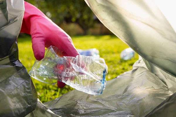 Joven voluntario con bolsa de basura recogiendo basura al aire libre, limpio — Foto de Stock