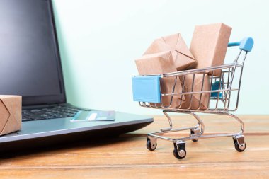 Online alışveriş konsepti. Alışveriş sepeti, küçük kutular, dizüstü bilgisayar ve 