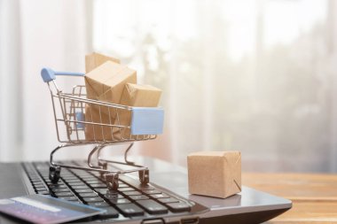 Online alışveriş konsepti. Alışveriş sepeti, küçük kutular, dizüstü bilgisayar ve 