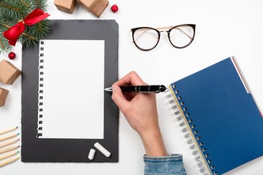 Noel mektubu beyaz masaya süslemeli kağıt üzerine yazılmış.